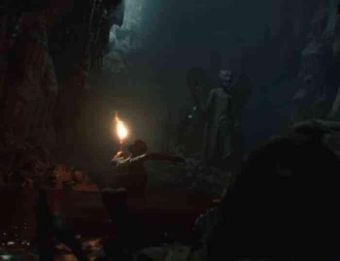 A screenshot of a character wandering through an underground tomb with a torch from House of Ashes.